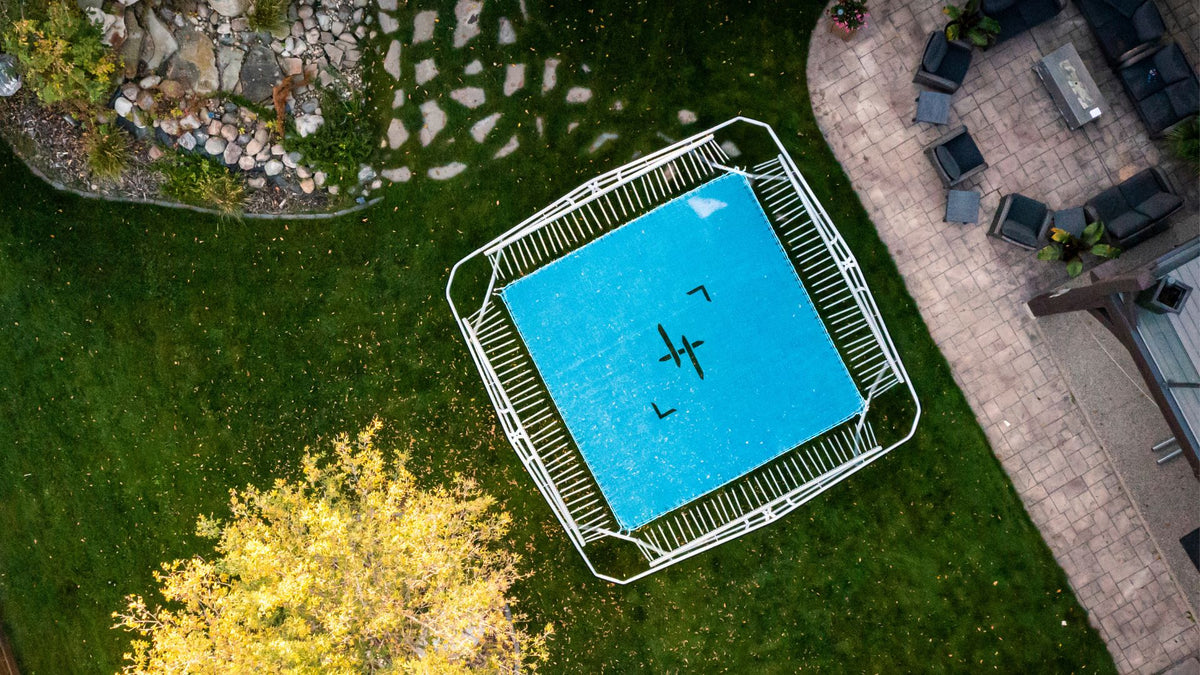 Trampoline on grass with patio and garden in the background