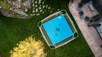 Trampoline on grass with patio and garden in the background