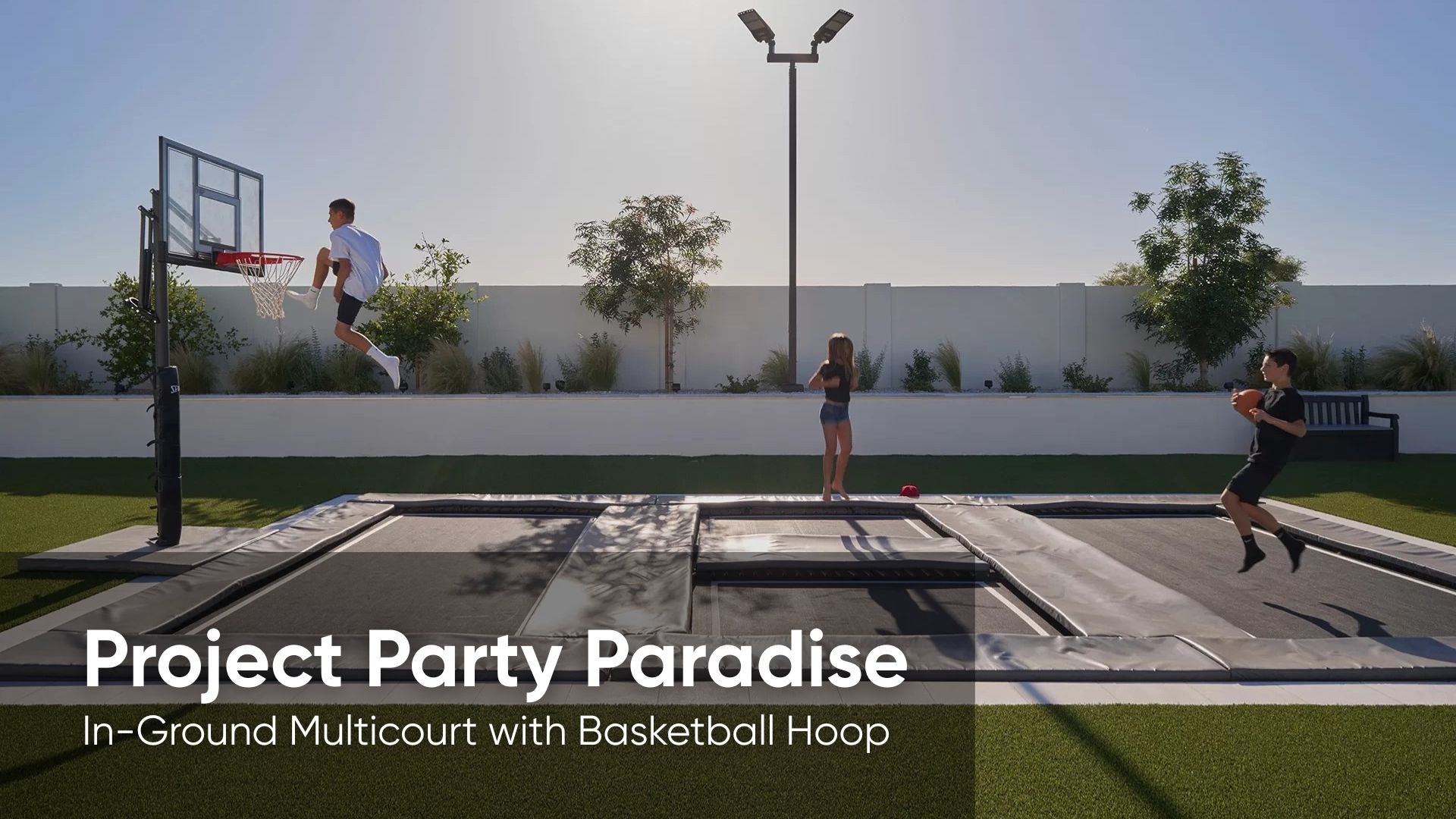 In-ground multicourt with basketball hoop and people playing basketball.