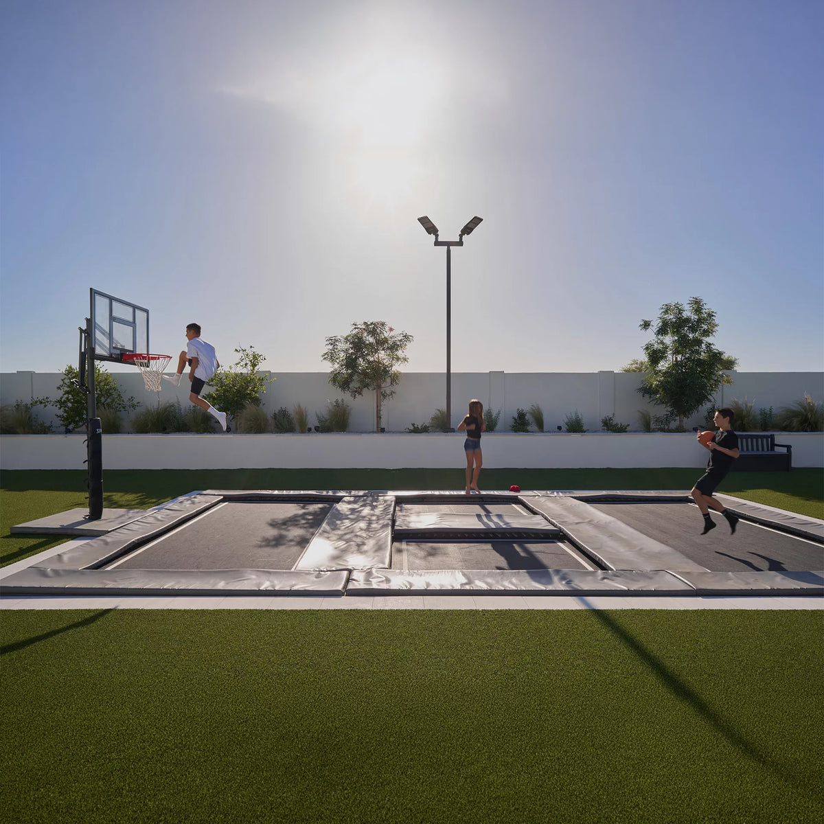 In-ground trampoline park in a backyard with professional basketball hoop